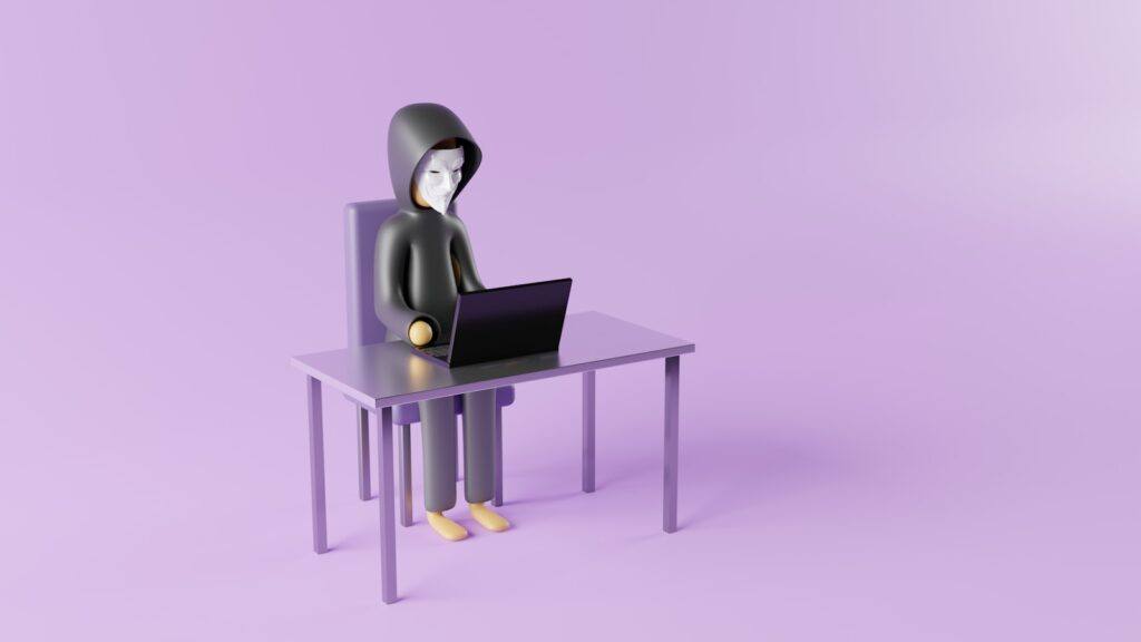 a person sitting at a desk with a laptop on it